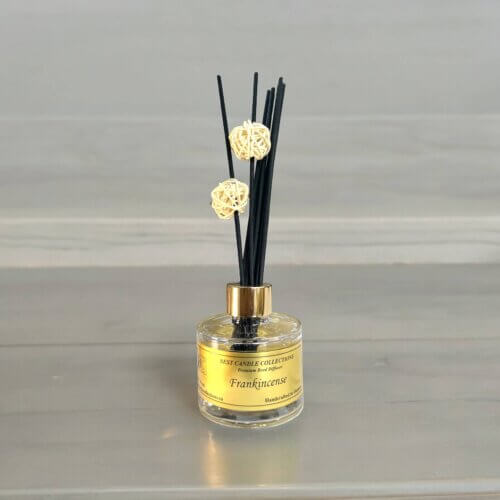 Frankincense Reed Diffuser Bottle with reeds in the bottle on a table